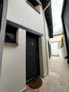 une porte noire sur le côté d'une maison dans l'établissement La maison d’Hélèna, à Montauban