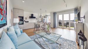 uma sala de estar com um sofá azul e uma mesa em Apartamenty Sun & Snow Hel Centrum em Hel