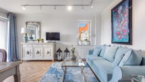 un soggiorno con divano blu e TV di Apartamenty Sun & Snow Hel Centrum a Hel