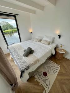 a bedroom with a large bed with a large window at Surla Houseboat De Saek with tender in Monnickendam