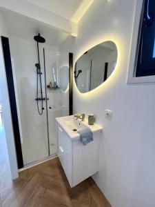 a white bathroom with a sink and a mirror at Surla Houseboat De Saek with tender in Monnickendam