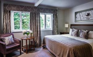 a bedroom with a bed and a chair and a window at Bailbrook House Hotel, Bath in Bath