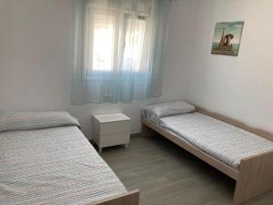 a bedroom with two beds and a window at Villa El Lagar in Novo Sancti Petri +10 photos