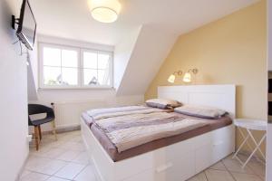 um quarto com uma grande cama branca num quarto em Zweite Heimat inkl WLAN em Grömitz