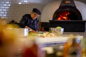 a man preparing food in a kitchen with an oven at Octant Santiago in Santiago do Cacém
