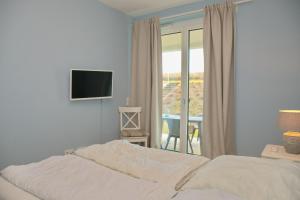 um quarto com uma cama e uma porta de vidro deslizante em Seeblick Gartenmaisonette 6 inkl WLAN em Grömitz