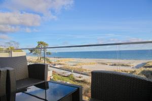 een balkon met uitzicht op het strand en de oceaan bij Seeblick Seaside 16 inkl WLAN in Grömitz