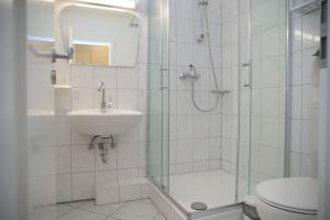 La salle de bains est pourvue d'une douche, d'un lavabo et de toilettes. dans l'établissement Grömitz- Center I App 540 inkl WLAN, à Grömitz