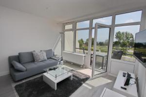 - un salon avec un canapé et une grande fenêtre dans l'établissement Villa am Meer App 53 inkl WLAN, à Grömitz
