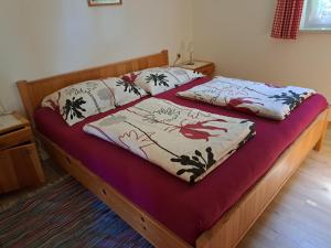 a bed in a bedroom with two pillows on it at Bungalow Raschun Grabelsdorf Etruskerweg 12 / 9122 St. Kanzian in Grabelsdorf