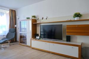 - un salon avec une grande télévision à écran plat dans l'établissement Haus Belvedere App 34 WLAN inkl, à Grömitz
