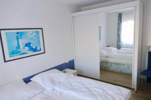 - une chambre avec un miroir et un lit dans l'établissement Haus Belvedere App 34 WLAN inkl, à Grömitz