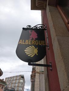 un panneau sur le côté d'un bâtiment dans l'établissement Albergue de Peregrinos Villa de Luarca, à Luarca