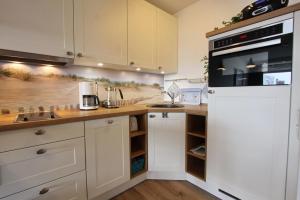 a kitchen with white cabinets and a counter top at Kaiserhof App 444 inkl WLAN in Grömitz