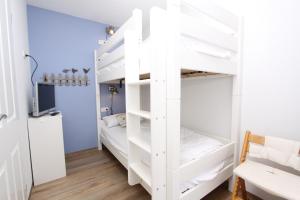 a room with two bunk beds with a tv at Kaiserhof App 444 inkl WLAN in Grömitz