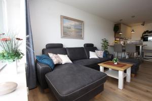 a living room with a couch and a table at Kaiserhof App 444 inkl WLAN in Grömitz +1 photo