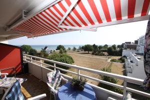 a balcony with an umbrella and a view of the ocean at Kaiserhof App 444 inkl WLAN in Grömitz