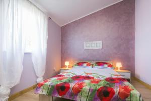 a bedroom with a bed and a purple wall at Apartment Gino in Ravni