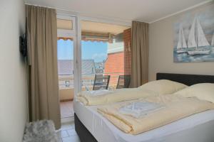 - une chambre avec 2 lits et une fenêtre avec un balcon dans l'établissement Haus Belvedere App 47 WLAN inkl, à Grömitz