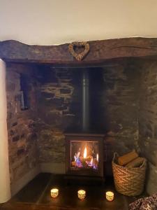 a fireplace in a stone room with candles in front of it at Sunnyside cottage in Braunton