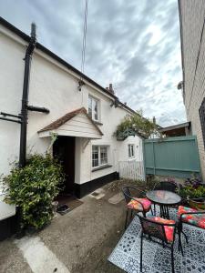 a patio with chairs and a table in front of a house at Sunnyside cottage in Braunton