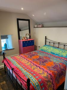 1 dormitorio con 1 cama con tocador rojo y espejo en Sunnyside cottage en Braunton