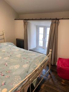 a bedroom with a bed and a window at Sunnyside cottage in Braunton