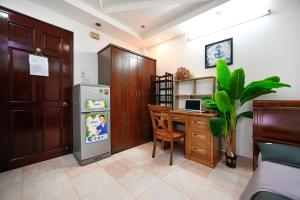 a kitchen with a desk and a refrigerator and a table at Ohio Hotel & Apartment in Ho Chi Minh City