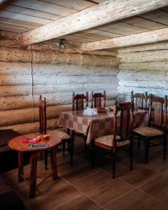 a dining room with a table and chairs and wooden walls at Komovi - Montenegrina Mountain house in Kolašin