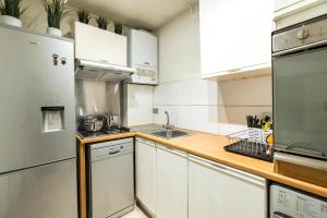 ロンドンにあるCozy 1 bedroom / Gloucester Road / Kensingtonのキッチン(白い家電製品、木製カウンタートップ付)