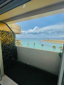 a balcony with a view of the ocean and palm trees at Apartamento VistaMar in La Línea de la Concepción