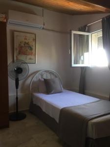a bedroom with a bed with a fan and a window at Villa Anja in Kusadası