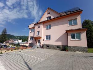 un gran edificio rosa con entrada de piedra en Vila U Parku, en Jeseník