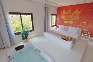 a hotel room with a bed and a bath tub at Aleph Boutique Hotel in Jbeil