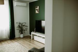 una sala de estar con TV de pantalla plana en un armario blanco en Apartament Magnolia -centrum en Tarnów