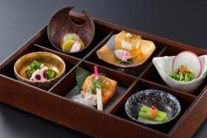 a wooden box filled with different types of food at Tachibanaya in Tsuruoka