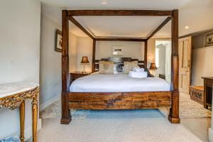 - une chambre avec un grand lit à baldaquin en bois dans l'établissement Browns Lane, à Woodstock