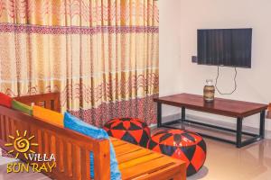 Villa Sun Ray في تيساماهاراما: غرفة معيشة مع تلفزيون وطاولة