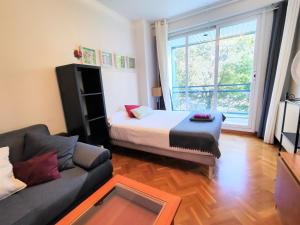 uma sala de estar com uma cama e um sofá em Mirasierra Suites Pamplona em Pamplona
