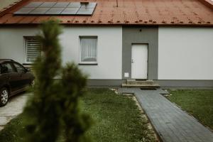 una casa blanca con techo rojo y un coche en Apartament Magnolia -centrum, en Tarnów