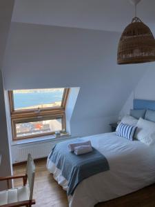 a bedroom with a large bed with a large window at EL TRASTERO DE PALMERO in A Coruña +5 photos
