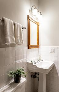 Baño blanco con lavabo y espejo en Spacious Stay near Yale in Downtown New Haven, en New Haven