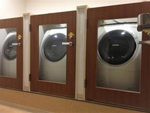 uma fila de três máquinas de lavar roupa numa casa de banho em the b nagoya em Nagoia