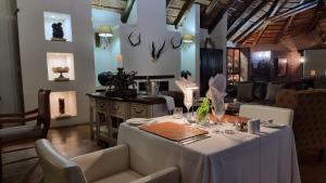 una sala da pranzo con tavolo e sedie bianchi di Bushwa Private Game Lodge a Vaalwater