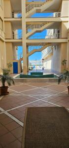 an empty courtyard in a building with palm trees at Apto Lux Sevilla in Seville