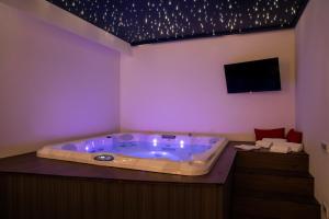 a jacuzzi tub in a room with a tv at L'OLEANDRO Room's - Suite & Spa da Giuseppe in Gonnosfanàdiga