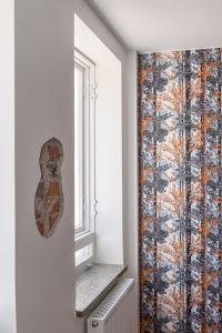 a room with a window and a wall with a patterned curtain at Hangon Asema 1 - lemmikit sallittu in Hanko