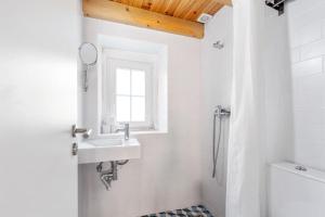 a white bathroom with a sink and a shower at Classic Lisbon Homes: Bright & Central in Belém in Lisbon