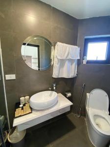 y baño con lavabo, aseo y espejo. en Đồng Chanh Villa Venuestay, en Hòa Bình