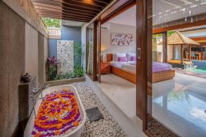 a bedroom with a tub and a bed and a pool at Nyanyi Sanctuary Villa by Ini Vie Hospitality in Tanah Lot